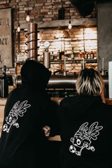 Zwei Blumenfisch Mitarbeiter im Team mit Matching Hoodies posieren